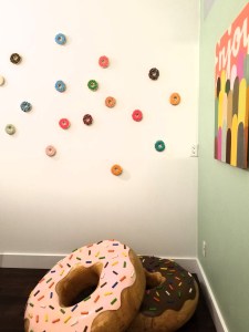 Installation with carved wood donut sculptures by Jon Reichert.